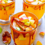 Three glasses of fruit punch garnished with cinnamon sticks and diced fruits, with a caramel drizzle on the rim.