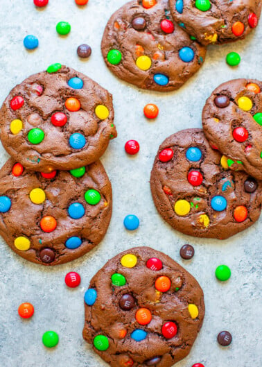 Chocolate cookies with colorful candy pieces on a light surface.