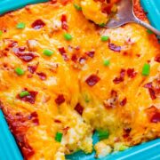 Baked cheesy casserole dish with a serving spoon.