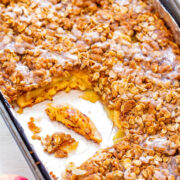 Freshly baked apple crisp in a baking dish with visible slices of apple and a crumbly oat topping.