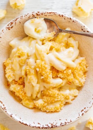 A bowl of creamy macaroni and cheese topped with breadcrumbs.