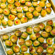 Roasted brussels sprouts on a baking sheet with browning on the edges.