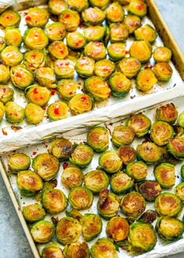 Roasted brussels sprouts on a baking sheet with browning on the edges.