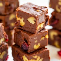 A stack of chocolate brownies with nuts and dried fruits visible in the slices.