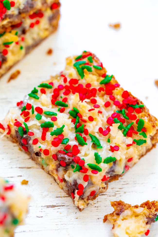a seven layer magic bar topped with holiday sprinkles 