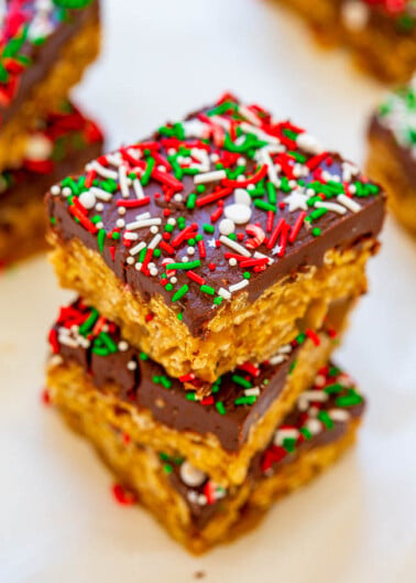 Festive rice cereal treats topped with chocolate and colorful holiday sprinkles.