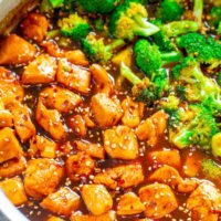 Stir-fried chicken and broccoli in a savory sauce, garnished with sesame seeds.