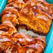 Baked cinnamon rolls in a blue baking dish.