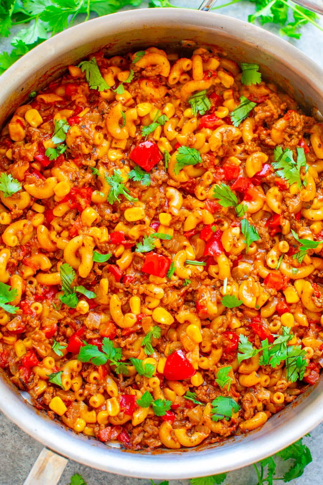 One-Skillet Tex Mex Beef Mac & Cheese - An EASY recipe that's made in ONE skillet so you don't have to cook the pasta separately!! Loaded with ground beef, peppers, tomatoes, cheese, and cilantro! A family FAVORITE that feeds a crowd!!