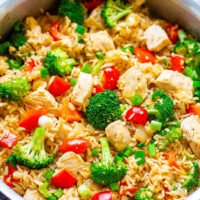 A pot of chicken and vegetable stir-fry with rice.