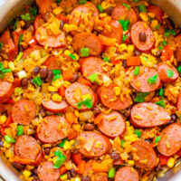 A bowl filled with sausage, rice, corn, beans, and diced vegetables.