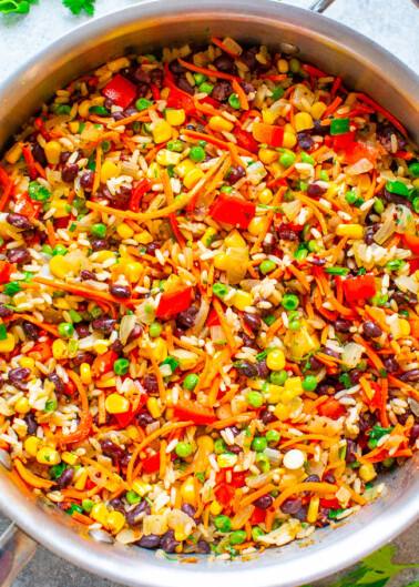 Colorful mixed vegetable rice dish in a stainless steel pan.