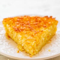A slice of golden-brown cornbread on a white decorative plate.
