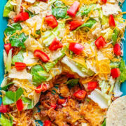 Layered beef taco salad with a scoop missing.