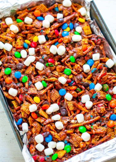 A tray of snack mix containing pretzels, cereal, candy-coated chocolates, and marshmallows.