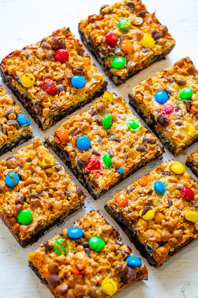Loaded Magic Brownie Bars — The softest, fudgiest, and BEST 7 layer brownies topped with coconut chocolate chips, butterscotch chips, toffee bits, M&M's, and more!! You will never want to cheat on these INCREDIBLE brownies after trying them!!  