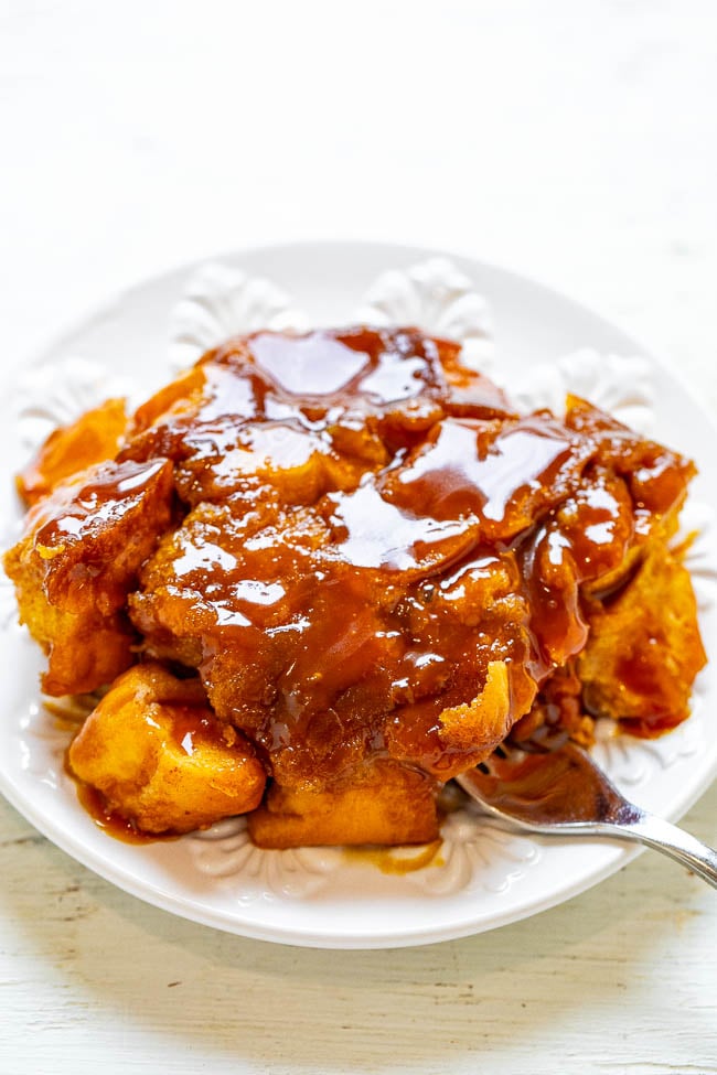 a portion of caramel overnight french toast bake on a white plate with a fork. 