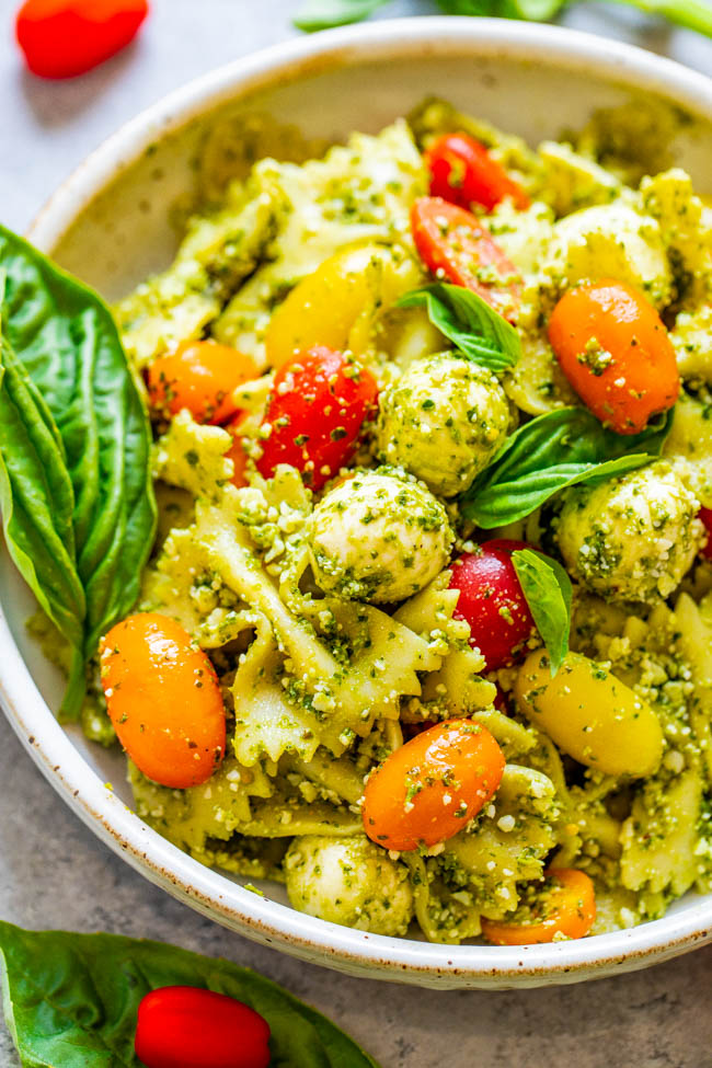 Tomato and Mozzarella Pesto Pasta Salad - Tender pasta, cherry tomatoes, and fresh mozzarella are coated in Parmesan cheese and DELICIOUS pesto sauce!! EASY, ready in 15 minutes, and great for easy meals with planned leftovers or for parties because it feeds a crowd!!