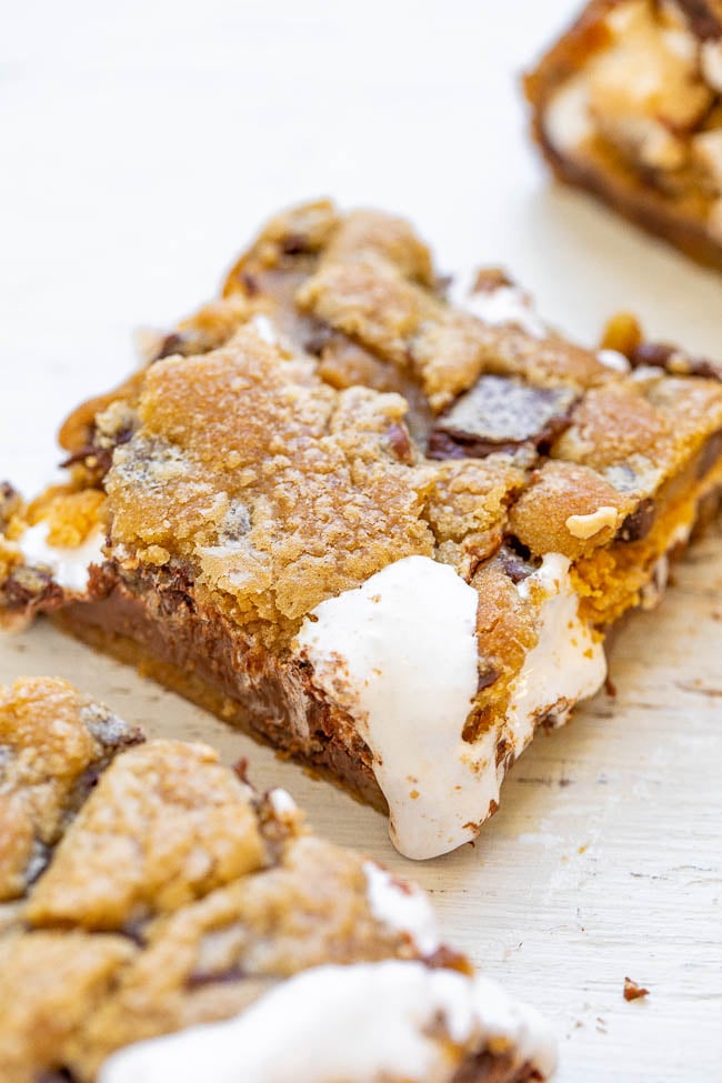 Chocolate Chip Cookie Smores Bars - Between layers of super soft chocolate chip cookie dough there's chocolate, marshmallows, and graham cracker crumbs for the most DECADENT smores ever!! So EASY and just 4 main ingredients!! 