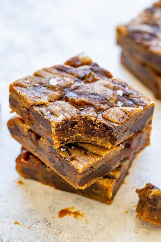 stack of three caramel blondies, with a bite missing from the top one