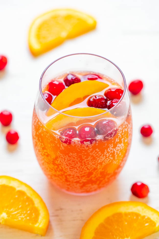 glass of alcoholic christmas punch garnished with orange slices and fresh cranberries 