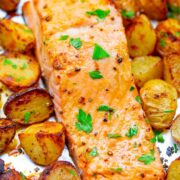 Sheet pan salmon and potatoes topped with parsley.
