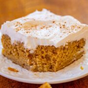 A slice of Snickerdoodle Poke Cake on a plate missing a corner bite.