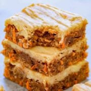A stack of three Carrot Cake Cream Cheese bars, the top bar missing a bite.