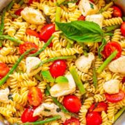 A pot of chicken asparagus pasta with tomatoes.