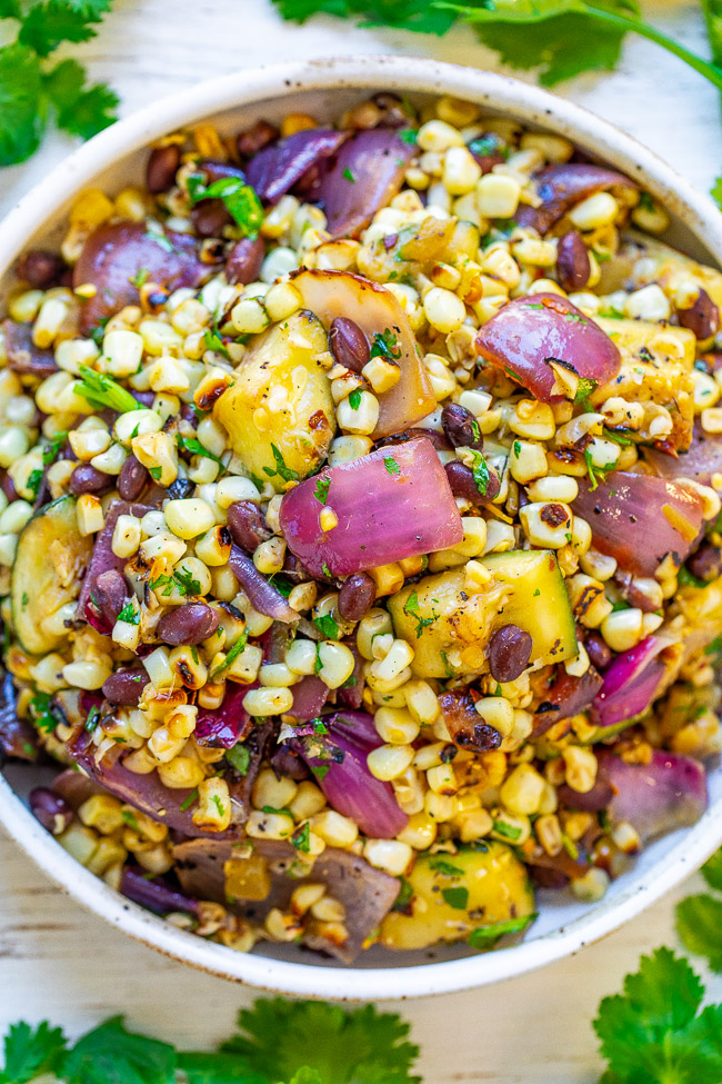 Mexican Corn and Black Bean Salad — An EASY corn salad with black beans, zucchini, red onions, cilantro, lime juice, and more!! So much Mexican-inspired FLAVOR in every bite of this family favorite recipe that's sure to be a hit!!