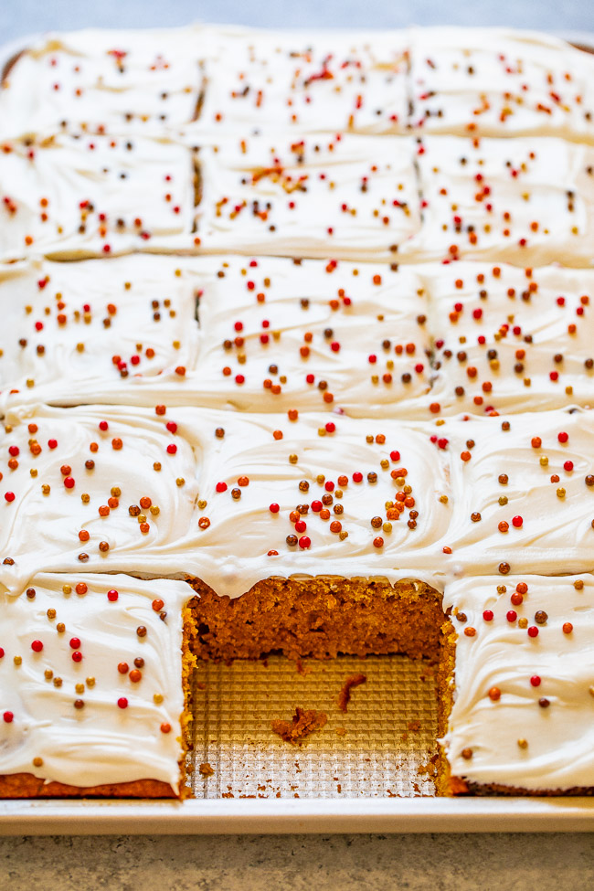 a pan of sliced pumpkin bars with cream cheese frosting 