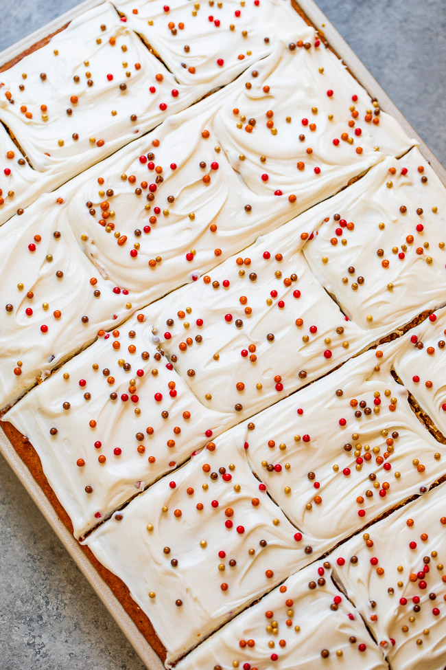 overhead view of sliced pumpkin bars with cream cheese frosting in a baking pan