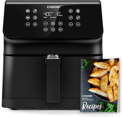 Black Cosori air fryer with digital display set to 400°F and 10 minutes. A recipe booklet with images of potato wedges is beside it.