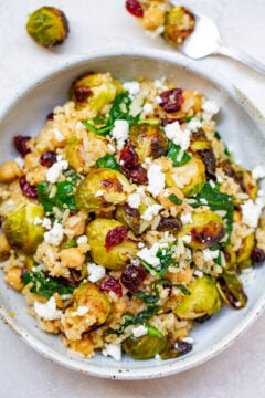 Roasted Brussels Sprouts Quinoa Chickpea Salad - A HEARTY salad that celebrates the flavors of fall including roasted Brussels sprouts and dried cranberries along with quinoa, chickpeas, spinach, and goat cheese!! Perfect for lunch, a meatless main, or a HEALTHY side dish on your holiday table!!