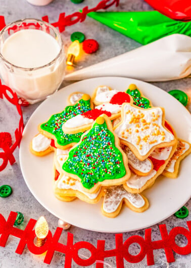 Christmas Cut Out Sugar Cookies - These traditional sugar cookies are just like Grandma used to make!! They're thin but still soft, topped with a simple 2-ingredient royal icing, and loaded with sprinkles! So festive and perfect for cookies exchanges or hostess gifts!!