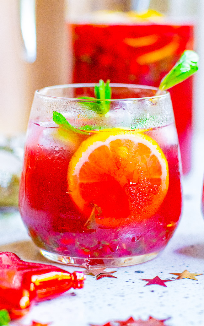 Pomegranate Mojito Punch - A FESTIVE twist on a classic mojito complete with pomegranate juice and pom arils while retaining plenty of fresh mint and of course the rum!! Fast, easy, SO TASTY, and perfect for holiday entertaining!! 