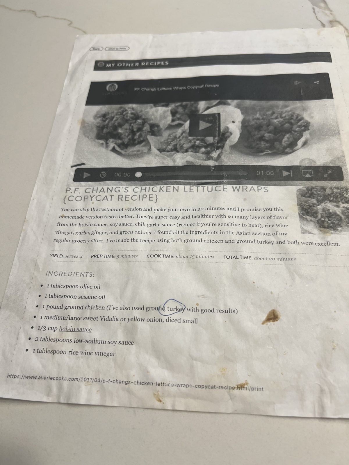 A printed recipe page for P.F. Chang’s Chicken Lettuce Wraps Copycat Recipe, showing a recipe title, ingredient list, cooking instructions, and food images at the top; the page has visible stains.