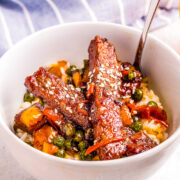 Mongolian Beef Bowls - These EASY Chinese-inspired Mongolian beef bowls are ready in just 10 minutes!! Loaded with rich savory flavor, crisp-tender vegetables, and served over rice! Faster than calling for takeout when you're craving Asian food!!