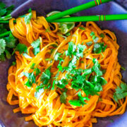 A bowl of Thai curry noodles topped with cilantro.