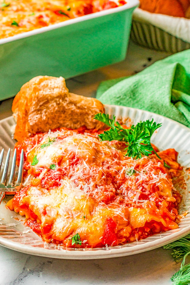 Cheesy Ravioli Lasagna - This EASY lasagna comes together with just four simple ingredients making it perfect for busy weeknights!! The whole family will LOVE this cheesy comfort food lasagna recipe! 