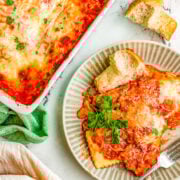 A plate of cheese ravioli lasagna next to a casserole dish.