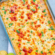 Mexican Baked Cheesy Street Corn Dip - A hot corn dip reminiscent of Mexican street corn!! Creamy, cheesy, spiked with lime juice, chili powder, and a serrano chile or jalapeno for a touch of heat! SO EASY and ready in 20 minutes!! Perfect for parties, potlucks, tailgating, or your next FIESTA!! 