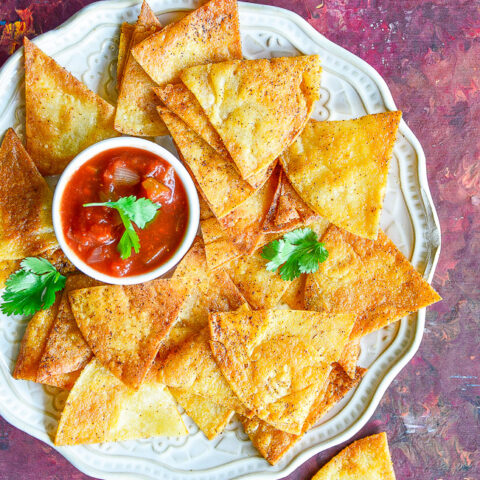 Baked Tortilla Chips - Making tortilla chips at home is FAST and EASY! Ready in just 20 minutes. These are BAKED not fried so they're healthier, too! Perfect for salsa, guac, or anytime you need tortilla chips!
