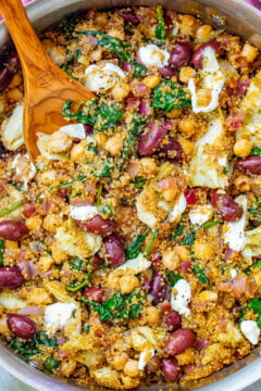 Mediterranean Quinoa and Chickpea Salad in a pot with a wooden spoon.