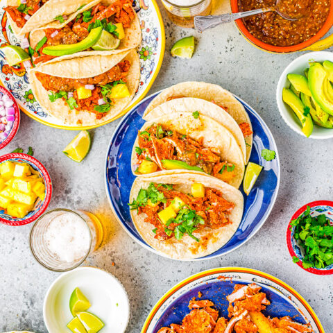 Tacos Al Pastor - Learn to make this staple Mexican recipe that includes thinly sliced pieces of pork marinated in a tangy, sweet pineapple sauce AT HOME!  Juicy, flavorful, tender pork served in tortillas with onions, cilantro, lime juice, and salsa! You'll want every night to be taco night! 