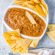 A bowl of pineapple chipotle salsa with tortilla chips.