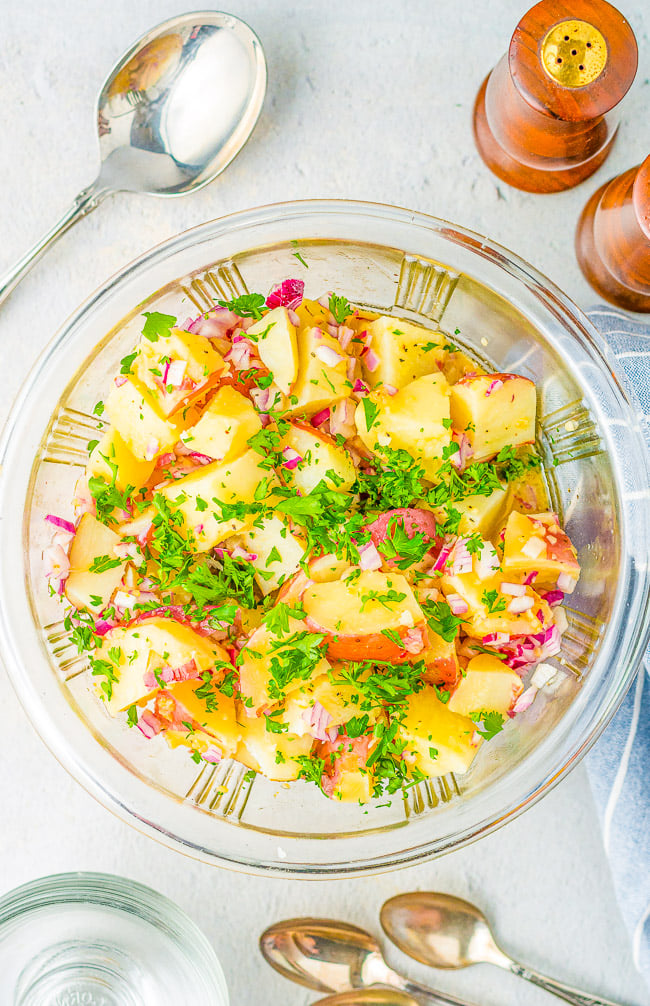 Warm German Potato Salad — A classic potato salad made with tender red potatoes, bacon, onions, and a tangy vinegar dressing! This no-mayo potato salad is a family favorite side dish that's perfect for parties, picnics, and potlucks!!