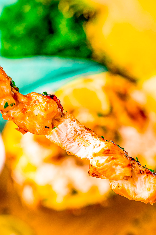 A grilled teriyaki chicken skewer with a bite taken out.