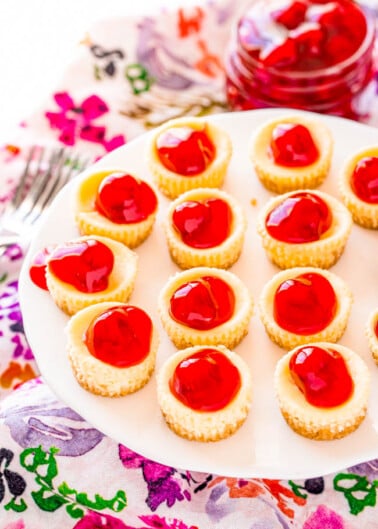 Mini Cherry Cheesecakes - Fun and adorable mini cheesecakes have a crunchy graham cracker crust, a creamy cheesecake filling, and are topped with cherry pie filling but you can top them with anything you’d like! EASY, sure to impress, and mini food always tastes BETTER!