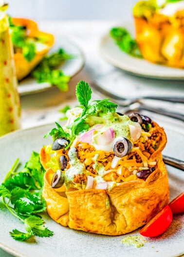 Beef Taco Salad Bowls - Making homemade taco salad bowls is so easy and they're perfect for holding this family-favorite taco salad including seasoned ground beef, black beans, cheese and more! Everything is topped with a creamy lime-cilantro dressing that'll have everyone finishing their salad!